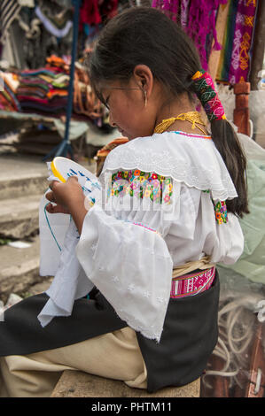 Otavalo, Ecuador - August 4, 2012: indische Mädchen in Nationale Kleidung verkauft die Produkte ihrer Weberei, wie üblich an Wochentagen auf der berühmtesten Märkte Stockfoto