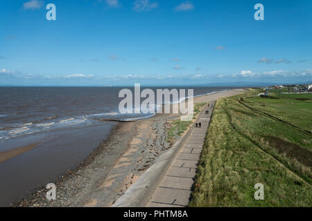 Blick von der Küstenwache entlang der ruhigen Promenade mit ein paar Spaziergänger, der Flut und den Golfplatz in Fleetwood, England, Großbritannien Stockfoto