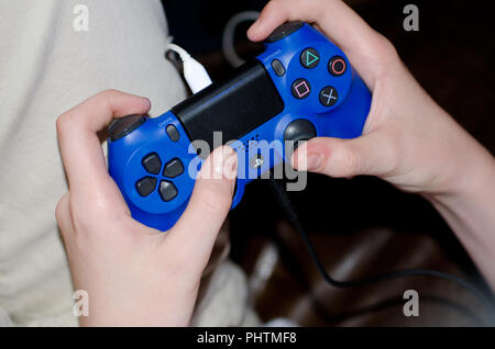 Blau Playstation Controller gehalten und verwendet werden Stockfoto