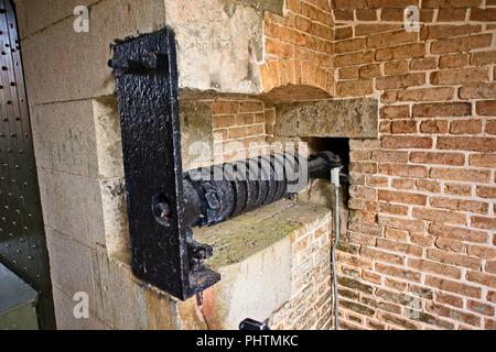 Ein Black Metal hebel, der durch einen alten Stein Festung am Fort Barrancas, Naval Air Station, Pensacola, Florida geht Stockfoto