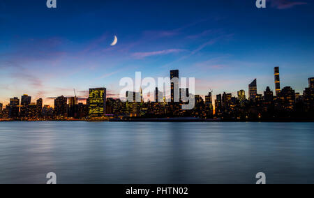 New York night skyline mit Halbmond am Himmel Stockfoto