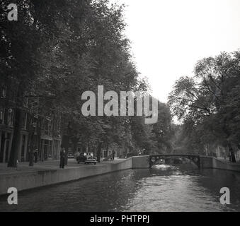 Juli, 1950, Amsterdam, eine Ansicht, die in dieser Zeit von einem der 165 Kanäle in der Stadt, der Netherands, in der Ferne, eine Brücke, von denen es 1281. Stockfoto