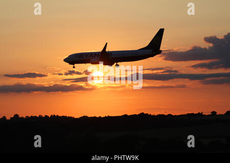 Eine ryanair Boeing 737 Jet EI-ESW fliegt vor der untergehenden Sonne wie es macht seine endgültige Annäherung in Edinburgh Airport