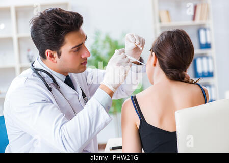 Arzt, Patienten einchecken Ohr während der medizinischen Untersuchung Stockfoto