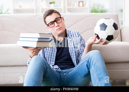 Junge Studenten, die versuchen, zu studieren und spielen Fußball Stockfoto