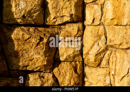 Stein Wand als Hintergrund oder Textur. Ein Beispiel von Mauerwerk als Verkleidung von Außenwänden. Stockfoto