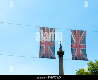 Anzeigen von Nelson's Column durch zwei Union Jacks gegen einen klaren blauen Himmel. Stockfoto