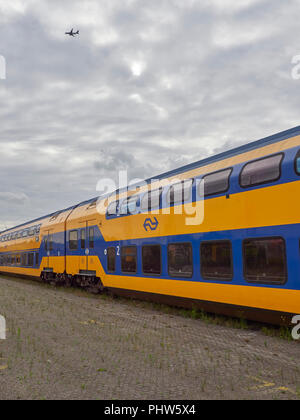 Personenwagen aus dem Niederländischen Städtische Eisenbahn- unternehmen in einer Linie auf Titel zu einem Container Terminal in Den Haag, Niederlande. Stockfoto