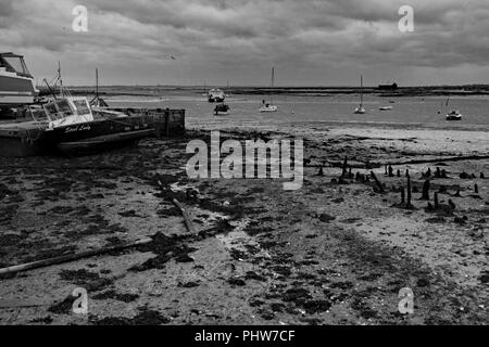 Wattenmeer und Boote, die an der West Mersea Island in Essex, England bei Ebbe Strand gesetzt sind. Stockfoto