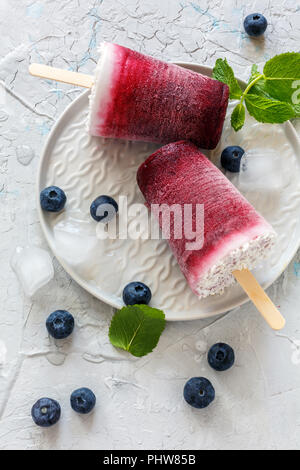 Hausgemachte Kokosnuss Eis am Stiel mit frischen Beeren. Stockfoto