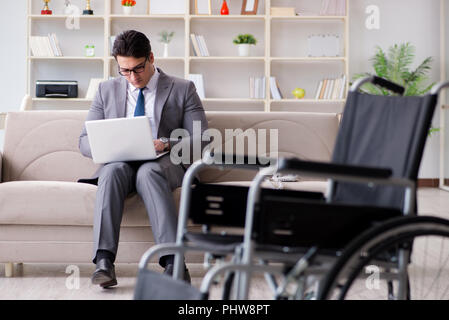 Dsabled Geschäftsmann auf Rollstuhl arbeiten Home Stockfoto