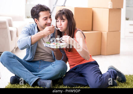 Junge Familie essen, das in der neuen Wohnung nach dem Einzug Stockfoto