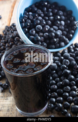 Weiße Schüssel voll mit gefrorenen Aronia Beeren Stockfoto