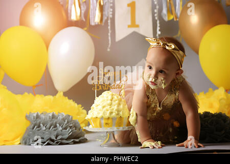 Little Baby Geburtstag ein Jahr Mädchen brechen ihre yellow cake Stockfoto