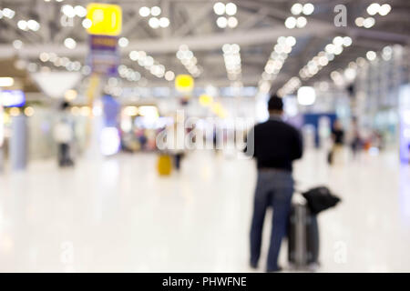 Defokussierten blurry Leute mit Gepäck in der Nähe von Terminal Wartebereich am Flughafen. Abstrakte verschwommen Passagiere. Stockfoto