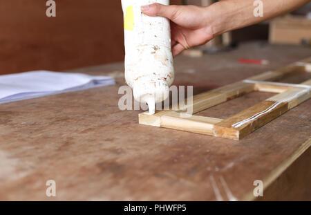 Tischler, Klebstoff auf ein Stück Holz Stockfoto