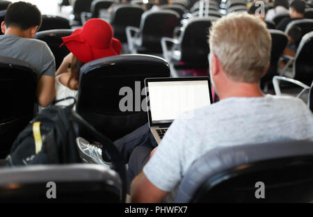 Passagier am Flughafen an seinem Tablet Computer Stockfoto