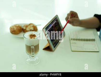 Ausgewählte Schwerpunkte Frau mit computer Tablet mit Kaffee Latte Stockfoto