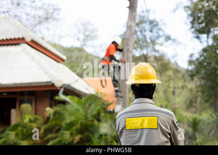 Elektriker Störungssucher Handwerker Arbeiter auf elektrische post Strommast Stockfoto