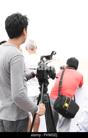 Mann mit Camcorder und Kamera arbeiten an der Aufzeichnung einer beach Polo Turnier Sport Stockfoto