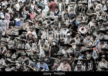 Indigenen Männer aus den umliegenden Gemeinden März in den Straßen während der Inti Raymi feiern in Cotacachi, Ecuador Stockfoto