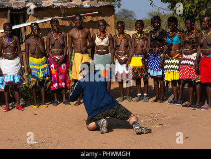 Europäische Touristen Filmen mudimba Stamm Frauen in traditioneller Kleidung, Cunene Provinz, Cahama, Angola Stockfoto
