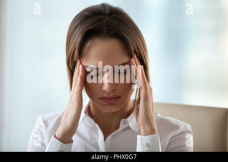 Frau Gefühl Kopfschmerzen oder Migräne berühren Tempel zu p entlasten Stockfoto