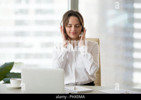 Entspannt Geschäftsfrau genießen, Musik hören über Kopfhörer an Stockfoto