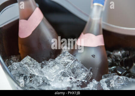 Flaschen von Rose Sekt auf Eis Schaufel closeup Stockfoto