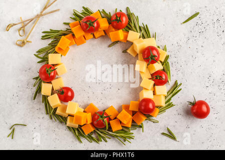 Weihnachten Kranz von Snacks aus Käse und Tomaten. Weihnachten Lebensmittel Hintergrund Konzept. Stockfoto