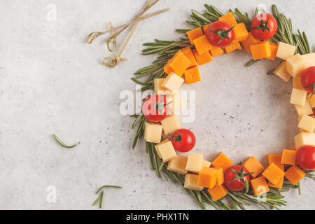 Weihnachten Kranz von Snacks aus Käse und Tomaten. Weihnachten Lebensmittel Hintergrund Konzept. Stockfoto