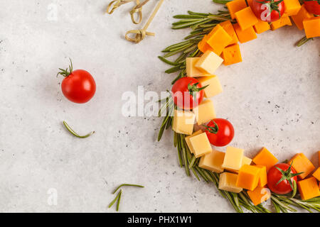 Weihnachten Kranz von Snacks aus Käse und Tomaten. Weihnachten Lebensmittel Hintergrund Konzept. Stockfoto