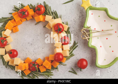 Weihnachten Kranz von Snacks aus Käse und Tomaten. Weihnachten Lebensmittel Hintergrund Konzept. Stockfoto