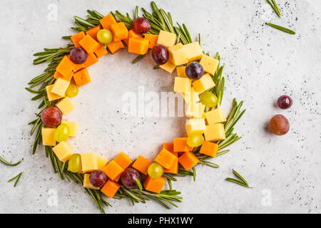 Weihnachten Kranz von Snacks aus Käse und Trauben. Weihnachten Hintergrund Konzept. Stockfoto