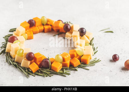 Weihnachten Kranz von Snacks aus Käse und Trauben. Weihnachten Hintergrund Konzept. Stockfoto