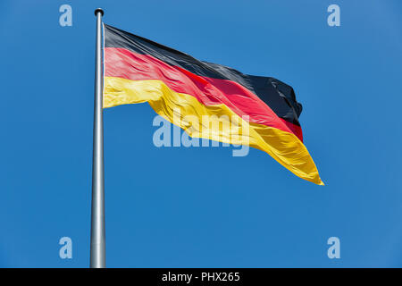 Deutsche Flagge auf dem Flagstaff winken gegen den klaren blauen Himmel bei sunnt Tag Stockfoto