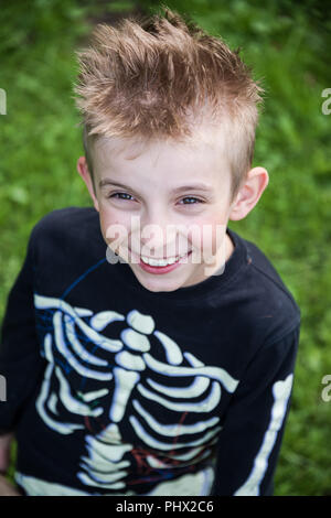 Lächelnde Junge im Skelett Kostüm Portrait, Halloween im Garten Stockfoto