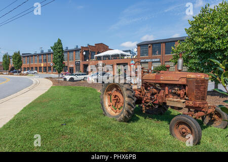 HICKORY, North Carolina, USA-9/1/18: Hollar Mühle, eine renovierte Mühle Gebäude, mit Fachgeschäften und Shops, mit antiken Farmall Traktor. Stockfoto