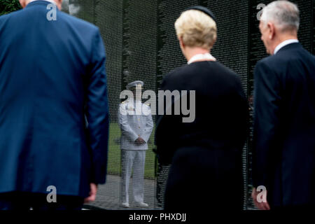 Marine Lieutenant Jack McCain, der Sohn von Senator John McCain, R-Ariz, in der Wand der Vietnam Memorial widerspiegelt als Jacks Mutter, Cindy McCain, begleitet von Verteidigungsminister Jim Mattis, rechts, und Präsident Donald Trump Stabschef John Kelly, Links, fährt nach einer Kranzniederlegung an der Vietnam Veterans Memorial in Washington, Samstag, Sept. 1, 2018, während einer Beerdigung Prozession, den Sarg ihres Mannes aus dem US Capitol zu Nationalen Kathedrale für eine Trauerfeier. McCain diente als Navy Pilot während des Vietnam Krieges und war ein Kriegsgefangenenlager für mehr als fünf Jahre. Credi Stockfoto