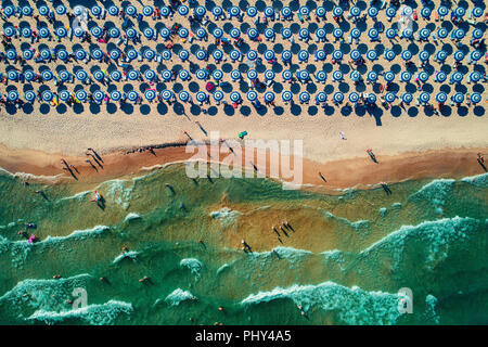 Aerial top view on the beach. Umbrellas, sand and sea waves Stockfoto