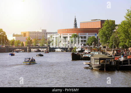 AMSTERDAM, NIEDERLANDE, 6. Juni 2018: Fluß Amstel mit niederländischen Nationalen Oper & Ballett auf dem Hintergrund, Amsterdam, Niederlande Stockfoto