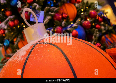 Weihnachtsdekoration mit einem Basketball Ball close-up und dekoriert frohe Weihnachten Pinie, hellen Hintergrund Stockfoto