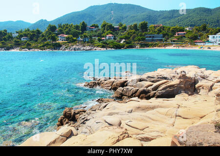 An der felsigen Küste in Vourvourou mit Bay, Griechenland Stockfoto