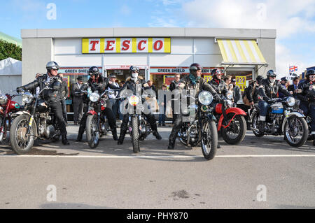 Zeitraum Motorradfahrer in Retro schwarz Leder am Goodwood Revival außerhalb der retro Tesco shop shop. Jahrgang, klassisch, zeitlos. Schritt zurück in der Zeit Stockfoto