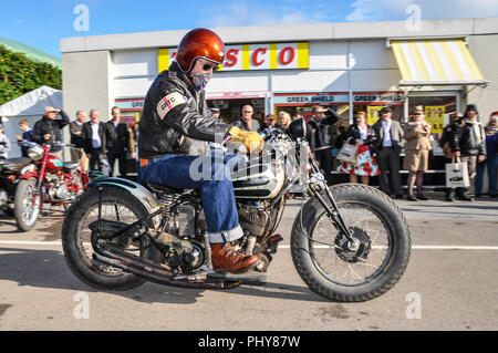 Zeitraum Motorradfahrer im Retro-look Leder am Goodwood Revival außerhalb der retro Tesco shop, Store. Jahrgang, klassisch, zeitlos. Schritt zurück in der Zeit Stockfoto