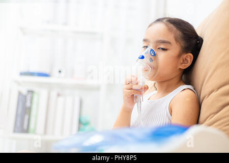 Cute Asian Kind patient Inhalationstherapie, die von der Maske von Inhalator mit weichen stream Rauch aus bronchodilatator. Stockfoto