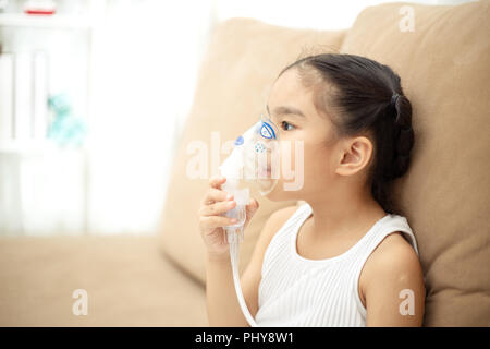 Cute Asian Kind patient Inhalationstherapie, die von der Maske von Inhalator mit weichen stream Rauch aus bronchodilatator. Stockfoto