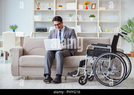 Dsabled Geschäftsmann auf Rollstuhl arbeiten Home Stockfoto