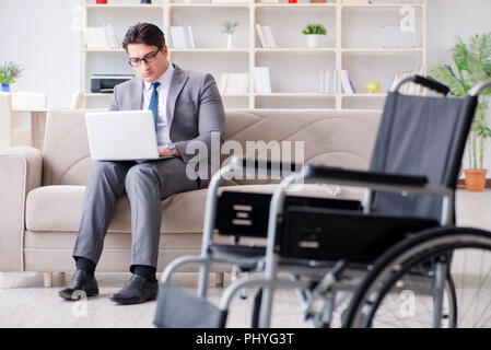 Dsabled Geschäftsmann auf Rollstuhl arbeiten Home Stockfoto