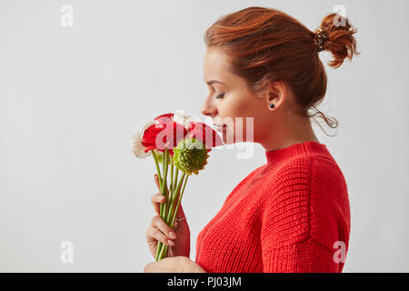 Schöne Mädchen im Profil, duftenden Blüten der Rose auf einem weißen Hintergrund. Stockfoto